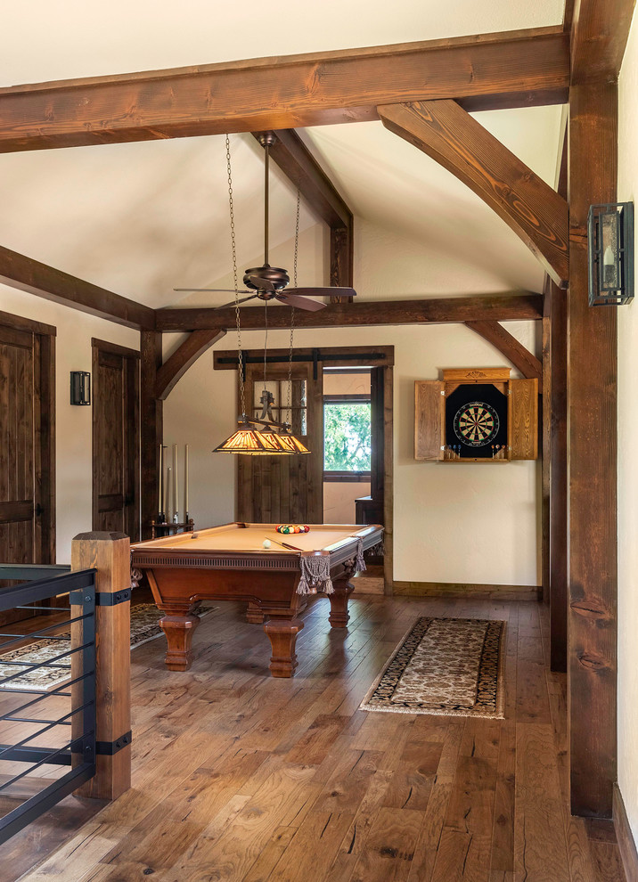 Imagen de sala de estar rural grande con paredes blancas, suelo de madera en tonos medios y suelo marrón