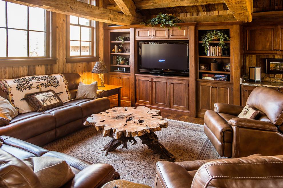 Foto de sala de estar rústica de tamaño medio con paredes marrones, suelo de madera en tonos medios y pared multimedia