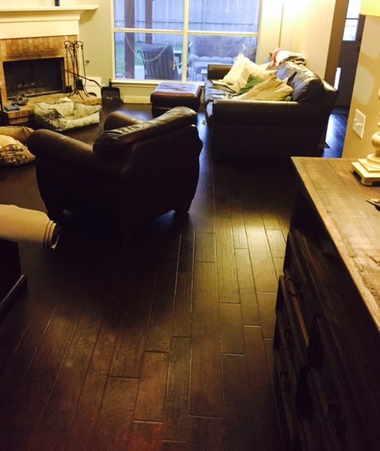 Großes, Offenes Uriges Wohnzimmer mit beiger Wandfarbe, dunklem Holzboden, Eckkamin und Kaminumrandung aus Stein in Dallas
