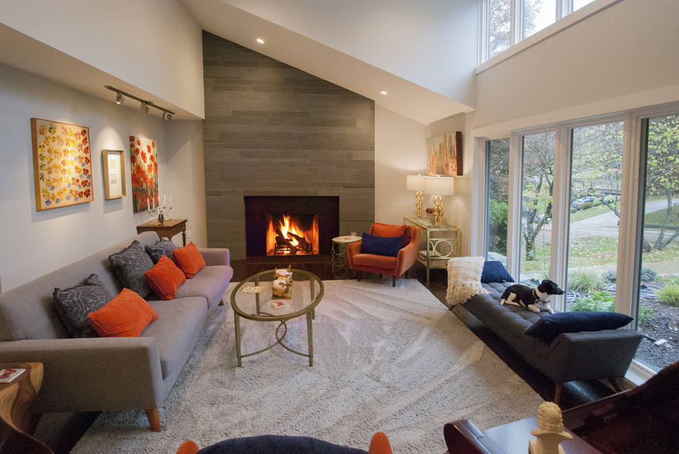 Réalisation d'une salle de séjour minimaliste de taille moyenne et ouverte avec une cheminée standard, un manteau de cheminée en pierre et un sol marron.