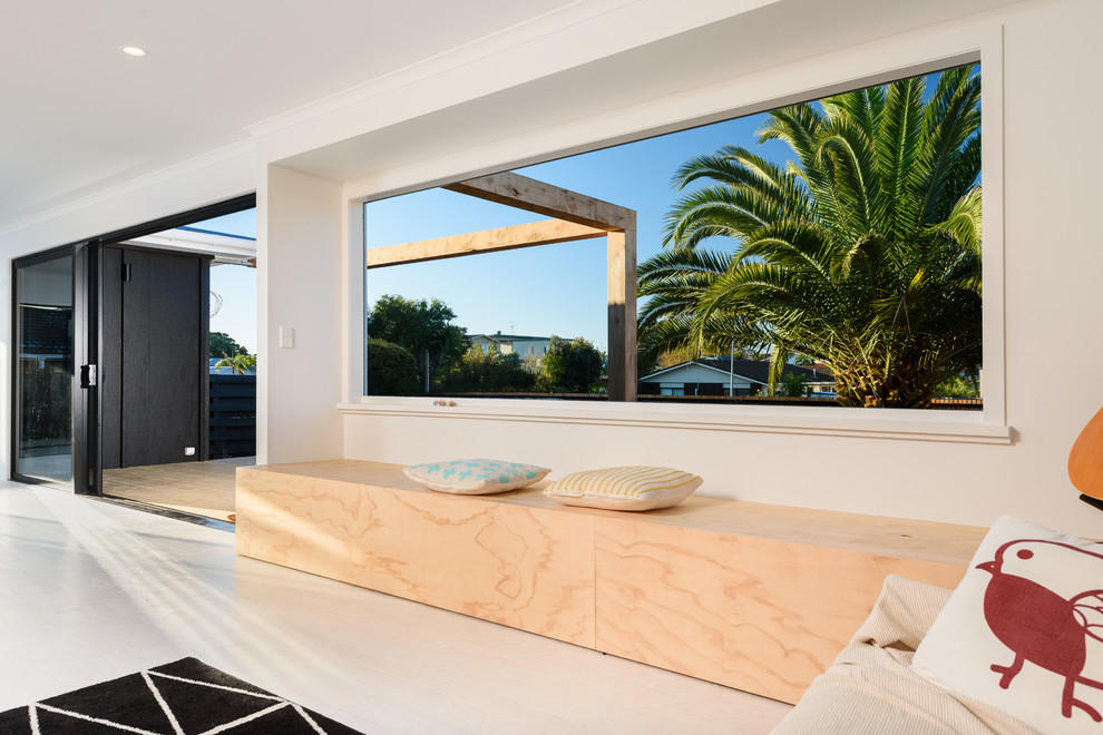 Modelo de sala de estar abierta costera pequeña sin chimenea con paredes blancas, suelo de madera pintada y suelo blanco