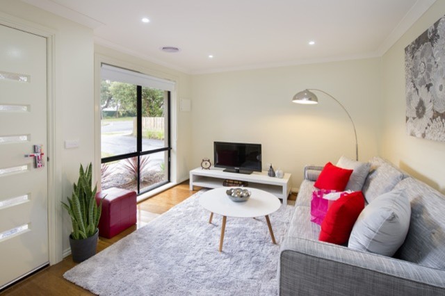 Пример оригинального дизайна: маленькая открытая гостиная комната в современном стиле с белыми стенами, полом из бамбука и отдельно стоящим телевизором для на участке и в саду