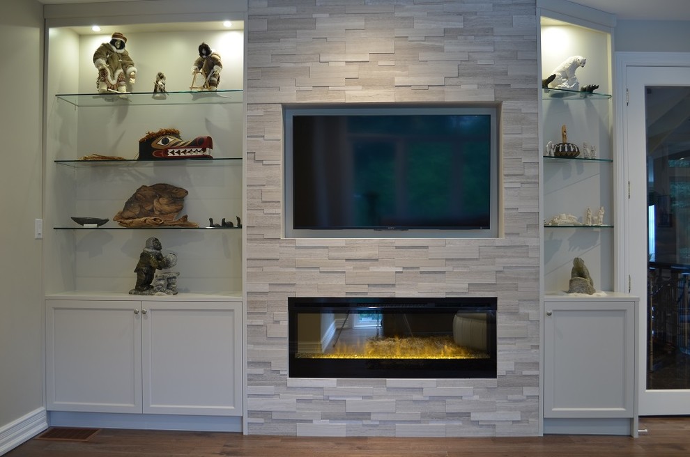 Diseño de sala de estar cerrada clásica renovada de tamaño medio con paredes beige, suelo de madera en tonos medios, chimenea lineal, marco de chimenea de piedra y televisor colgado en la pared