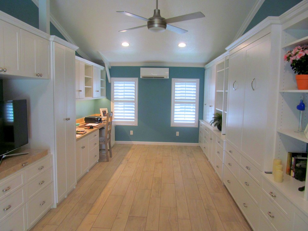 Immagine di un ampio soggiorno moderno chiuso con pareti blu e pavimento in laminato