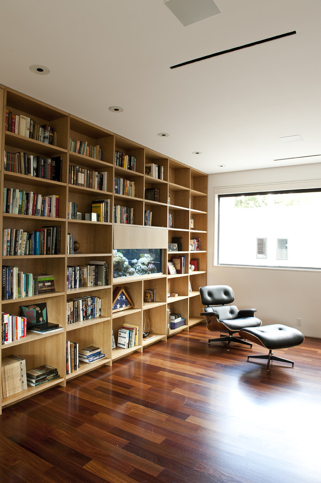 Idéer för att renovera ett funkis allrum, med ett bibliotek, vita väggar och mörkt trägolv