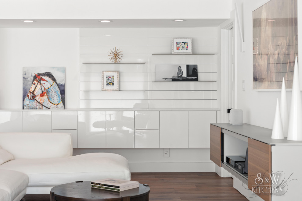 Diseño de sala de estar abierta contemporánea de tamaño medio con paredes blancas, suelo de madera en tonos medios, televisor colgado en la pared y suelo marrón