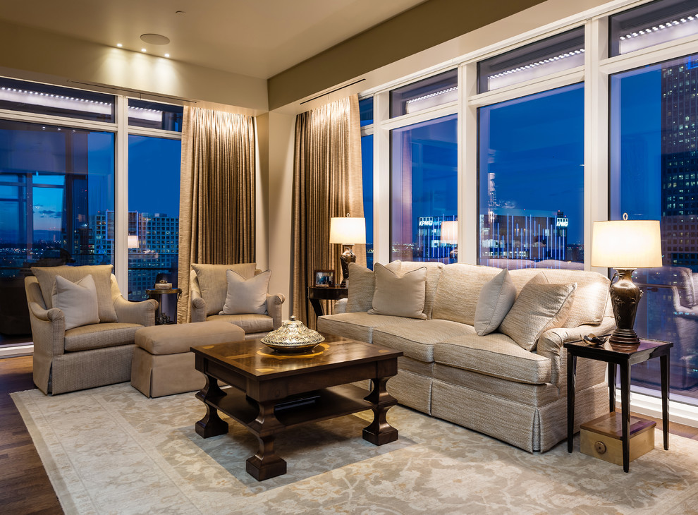 Modelo de sala de estar abierta clásica grande con paredes beige, suelo de madera en tonos medios y suelo marrón