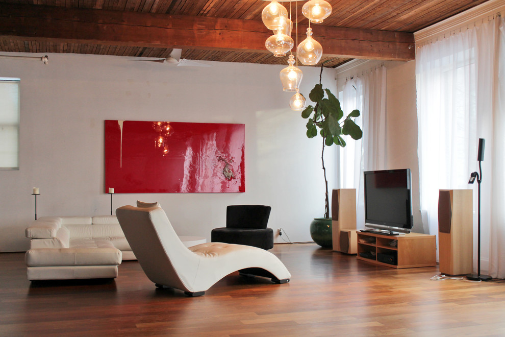 Inspiration pour une salle de séjour design avec un mur beige, un sol en bois brun et un téléviseur indépendant.