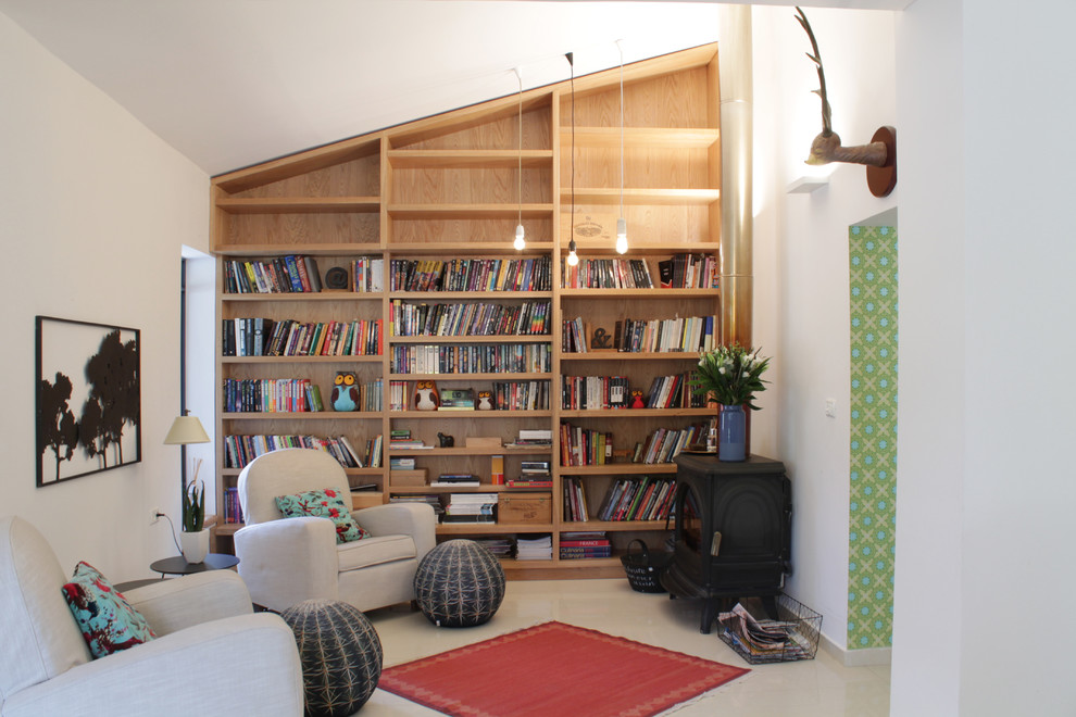 Bild på ett eklektiskt allrum, med ett bibliotek, vita väggar och beiget golv