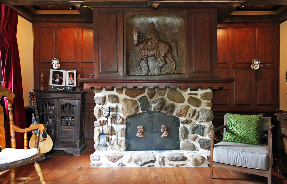 モントリオールにあるエクレクティックスタイルのおしゃれな独立型ファミリールーム (ベージュの壁、無垢フローリング、標準型暖炉、石材の暖炉まわり) の写真