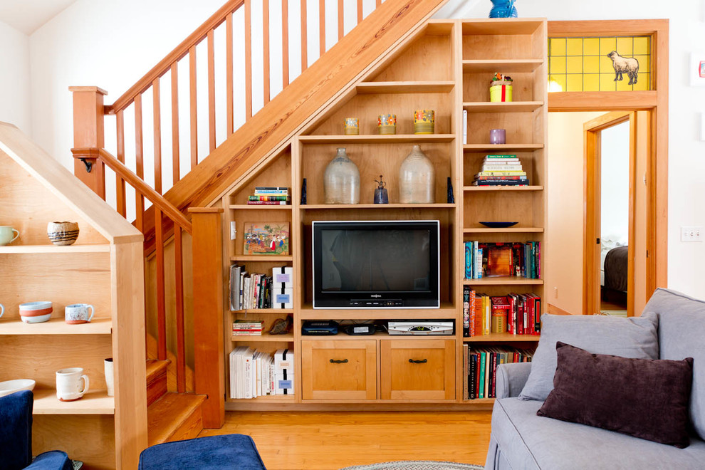 Diseño de sala de estar ecléctica con paredes blancas, suelo de madera en tonos medios y pared multimedia