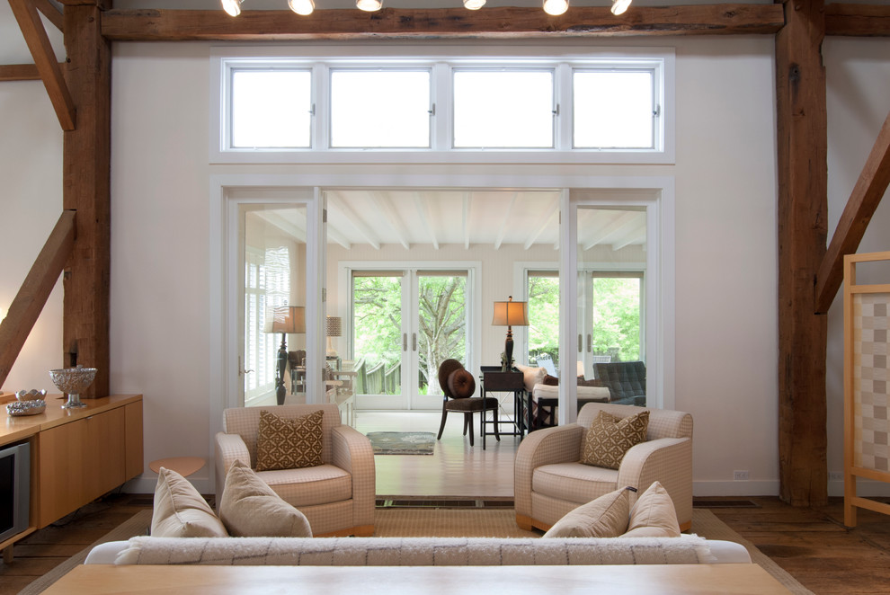 Cette photo montre une petite salle de séjour nature ouverte avec un mur blanc, un sol en bois brun et un téléviseur encastré.