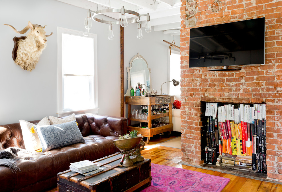 Foto de sala de estar con barra de bar bohemia con paredes blancas, suelo de madera en tonos medios y televisor colgado en la pared