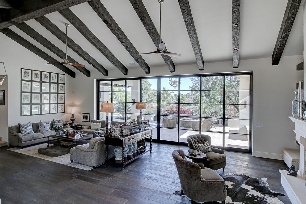 Ejemplo de sala de estar abierta clásica renovada grande con paredes blancas, suelo de madera en tonos medios, chimenea de doble cara, marco de chimenea de piedra y pared multimedia