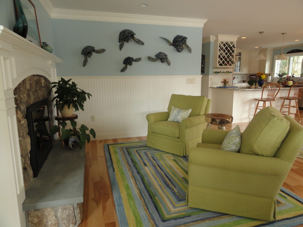 На фото: открытая гостиная комната среднего размера в морском стиле с зелеными стенами, светлым паркетным полом, двусторонним камином и фасадом камина из камня с