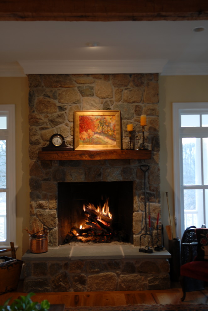 Ejemplo de sala de estar tradicional de tamaño medio con paredes beige, suelo de madera clara, todas las chimeneas y marco de chimenea de piedra