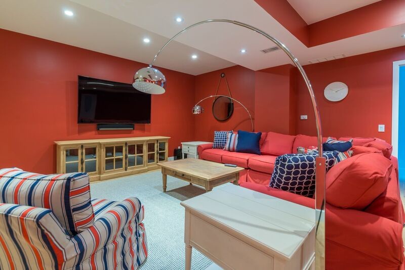 ボルチモアにある広いビーチスタイルのおしゃれな独立型ファミリールーム (ゲームルーム、赤い壁、カーペット敷き、暖炉なし、壁掛け型テレビ) の写真
