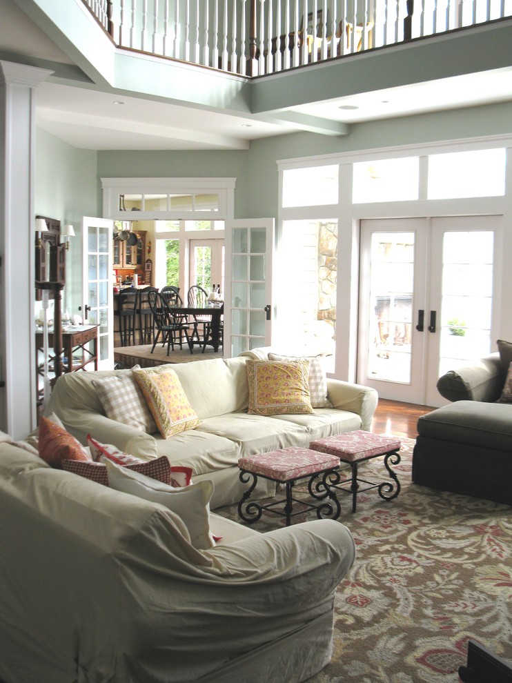 Diseño de sala de estar tipo loft costera grande sin televisor con paredes verdes y suelo de madera en tonos medios