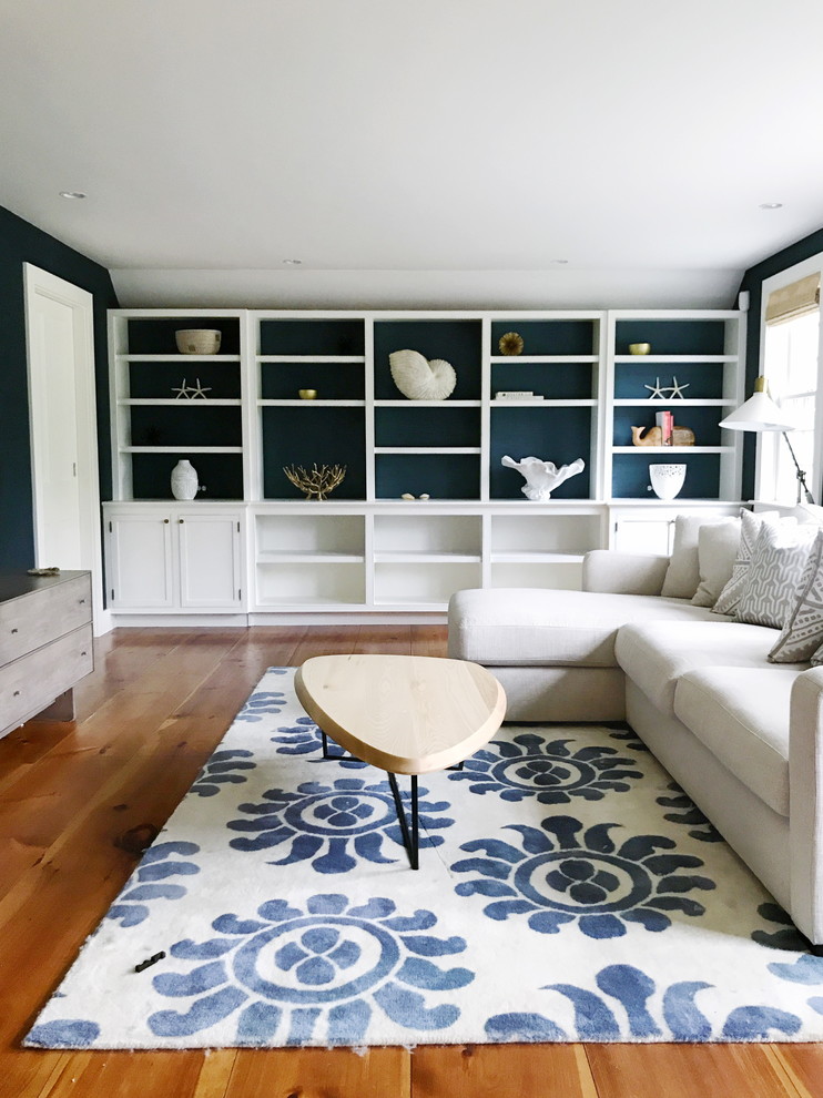 Immagine di un grande soggiorno costiero chiuso con pareti blu, pavimento in legno massello medio e TV autoportante