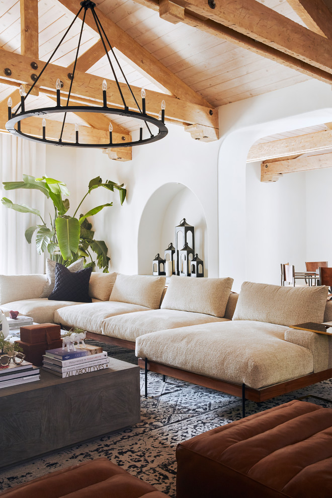 Diseño de sala de estar abierta mediterránea grande con paredes marrones, suelo de pizarra, todas las chimeneas, marco de chimenea de hormigón, televisor colgado en la pared y suelo marrón