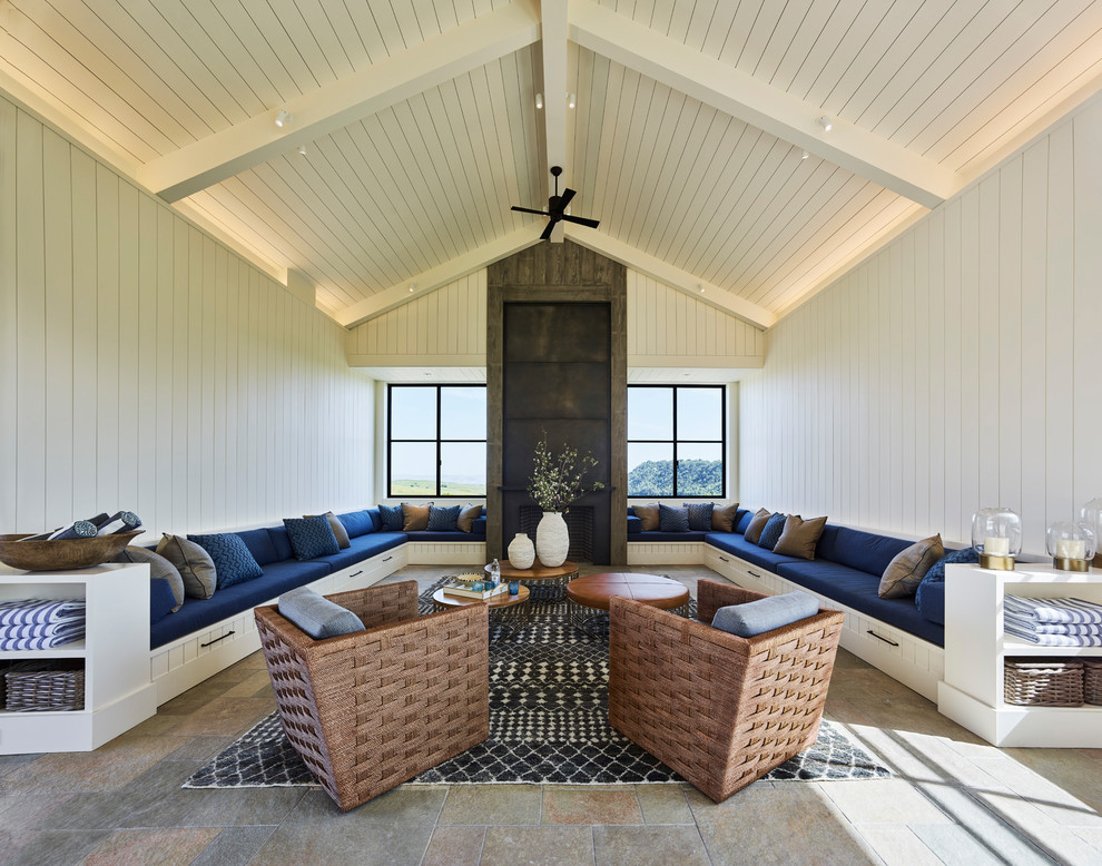 Country open plan games room in San Francisco with a game room, white walls, slate flooring, a standard fireplace, a concrete fireplace surround, a concealed tv and multi-coloured floors.