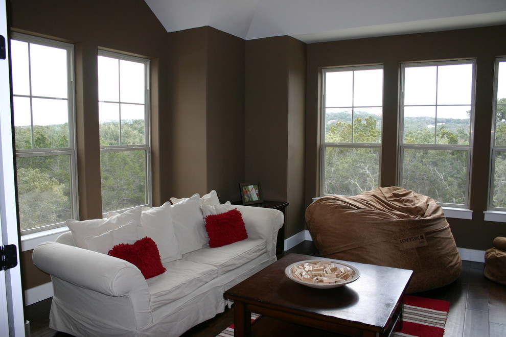Modelo de sala de estar cerrada campestre de tamaño medio sin chimenea con suelo marrón, paredes marrones, suelo de madera oscura y televisor colgado en la pared