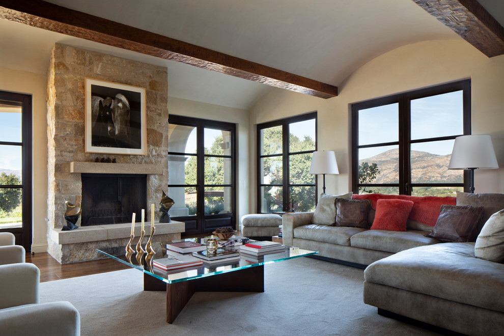 Mediterranes Wohnzimmer mit beiger Wandfarbe, braunem Holzboden, Kamin, Kaminumrandung aus Stein und braunem Boden in San Francisco