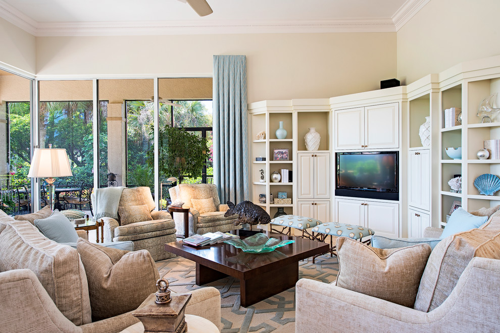 Aménagement d'une salle de séjour classique ouverte avec un mur beige et un téléviseur encastré.