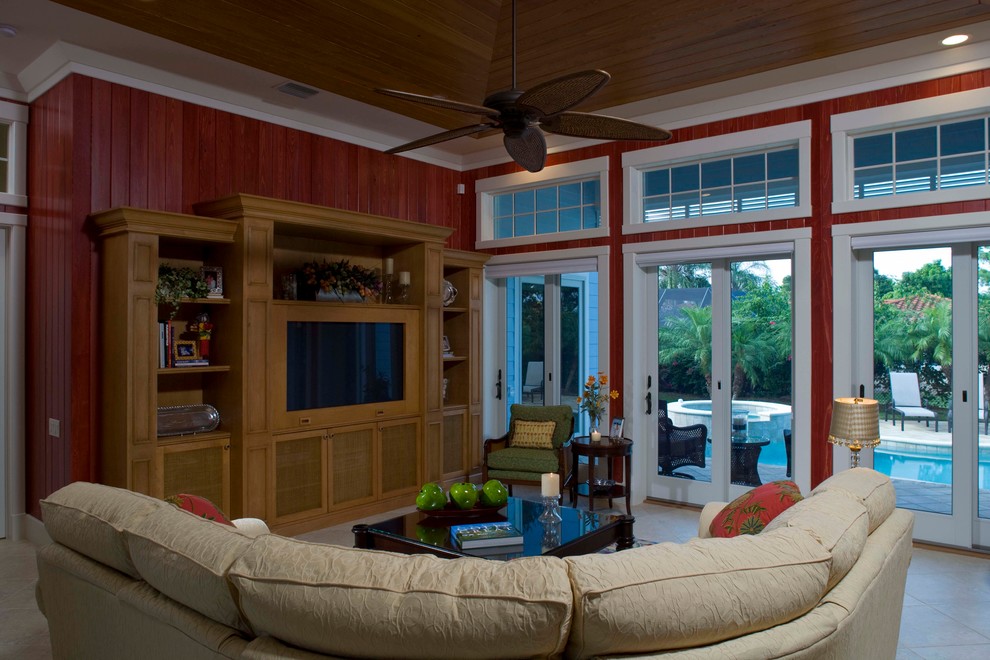 Imagen de sala de estar abierta exótica con paredes rojas y pared multimedia