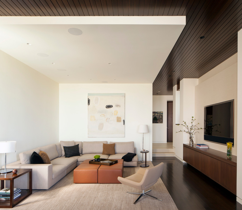 Großes, Abgetrenntes Modernes Wohnzimmer mit weißer Wandfarbe, dunklem Holzboden, TV-Wand und braunem Boden in Los Angeles