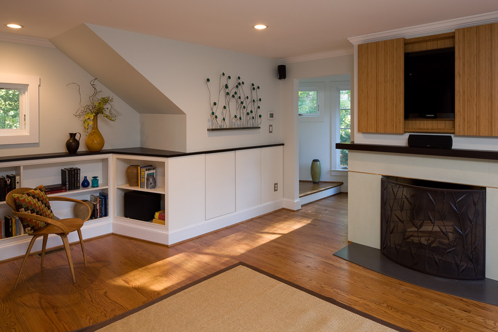 Foto di un soggiorno minimal di medie dimensioni con TV nascosta, pareti beige, parquet chiaro, camino classico e tappeto