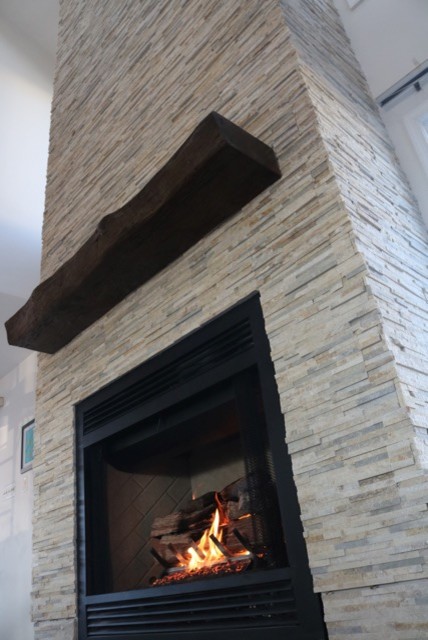 Ejemplo de sala de estar abierta marinera grande con marco de chimenea de piedra