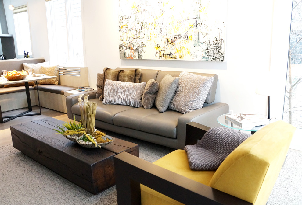 Esempio di un grande soggiorno minimalista aperto con pareti grigie, parquet chiaro e camino bifacciale