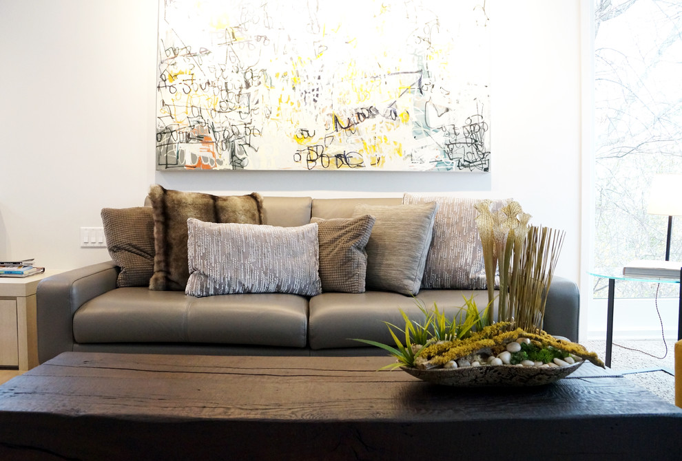 Modelo de sala de estar abierta moderna grande con paredes grises, suelo de madera clara y chimenea de doble cara