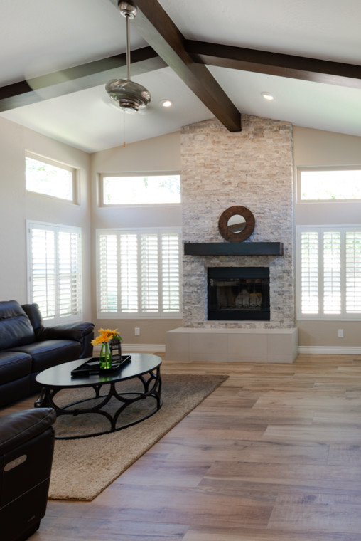Mid-sized transitional enclosed light wood floor and brown floor family room photo in Phoenix with beige walls, a standard fireplace, a stone fireplace and no tv