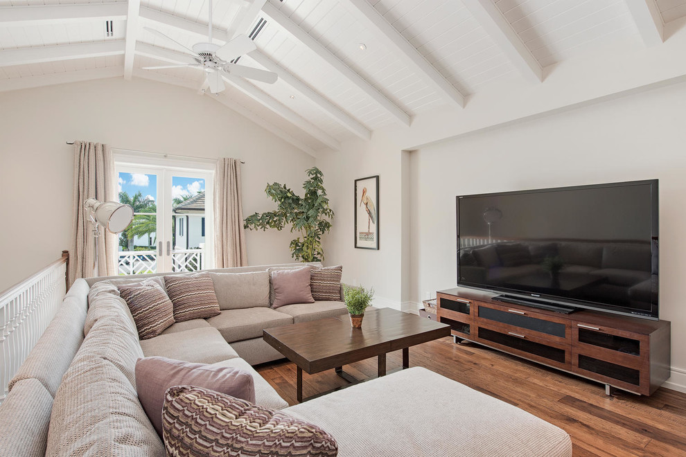 Diseño de sala de estar costera con paredes blancas, suelo de madera oscura y televisor independiente