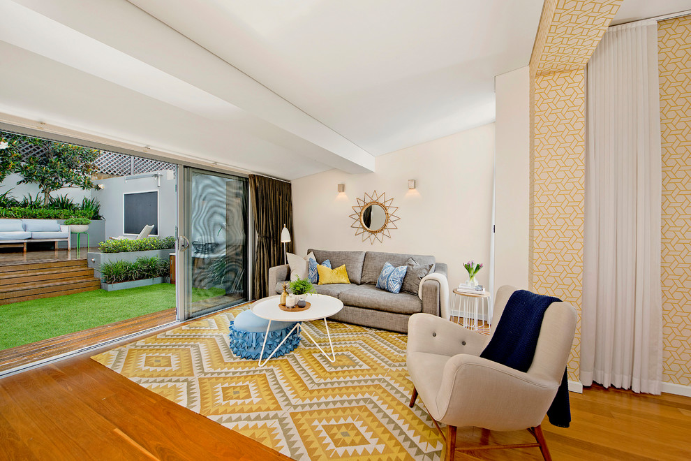 Offenes Mid-Century Wohnzimmer mit gelber Wandfarbe und braunem Holzboden