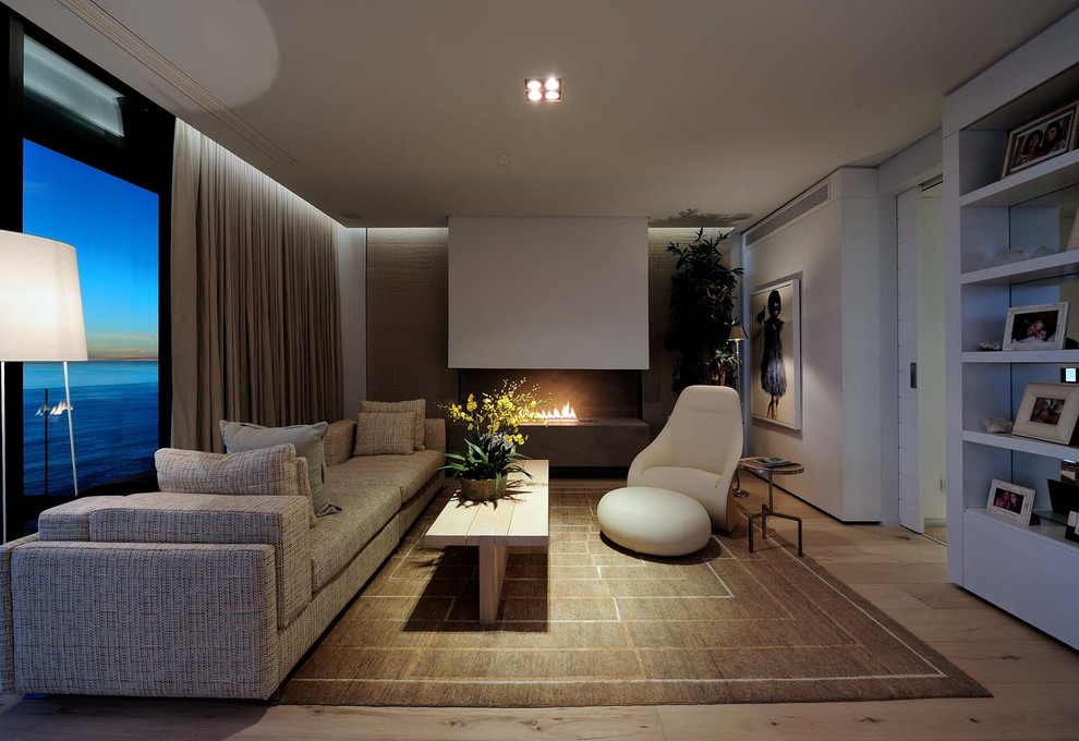 На фото: гостиная комната в современном стиле с белыми стенами и горизонтальным камином с