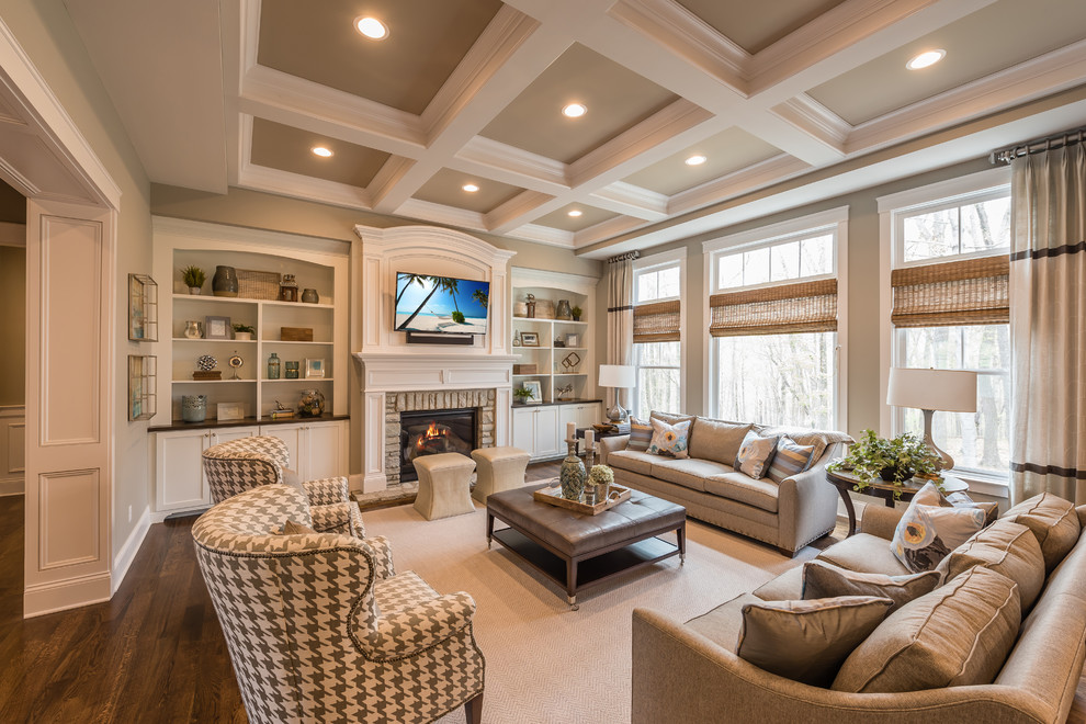 Family room - traditional enclosed dark wood floor family room idea in Cincinnati with beige walls, a standard fireplace, a stone fireplace and a wall-mounted tv