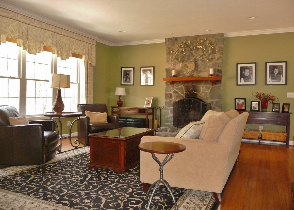 Imagen de sala de estar abierta clásica grande con paredes verdes, suelo de madera clara, todas las chimeneas, marco de chimenea de piedra y pared multimedia