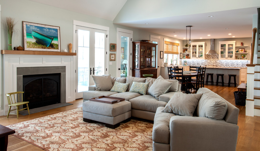 Example of a large arts and crafts open concept medium tone wood floor family room design in Providence with blue walls, a standard fireplace, a stone fireplace and a wall-mounted tv