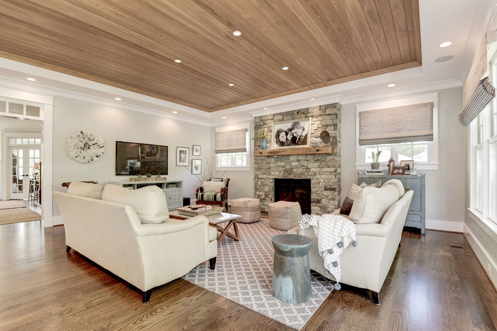 Classic open plan games room in DC Metro with grey walls, a standard fireplace, a stone fireplace surround and a wall mounted tv.