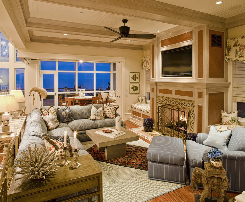 Foto de sala de estar tradicional con paredes beige, suelo de madera en tonos medios, todas las chimeneas, televisor colgado en la pared y alfombra