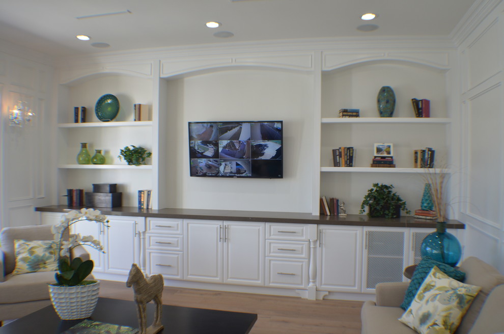 This is an example of a medium sized traditional open plan games room in Los Angeles with white walls, light hardwood flooring, no fireplace, a built-in media unit, brown floors and a game room.