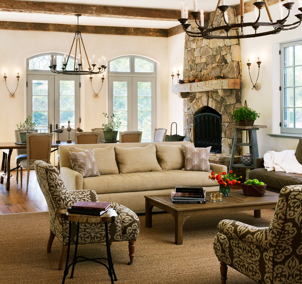 Imagen de sala de estar mediterránea con todas las chimeneas, marco de chimenea de piedra y moqueta