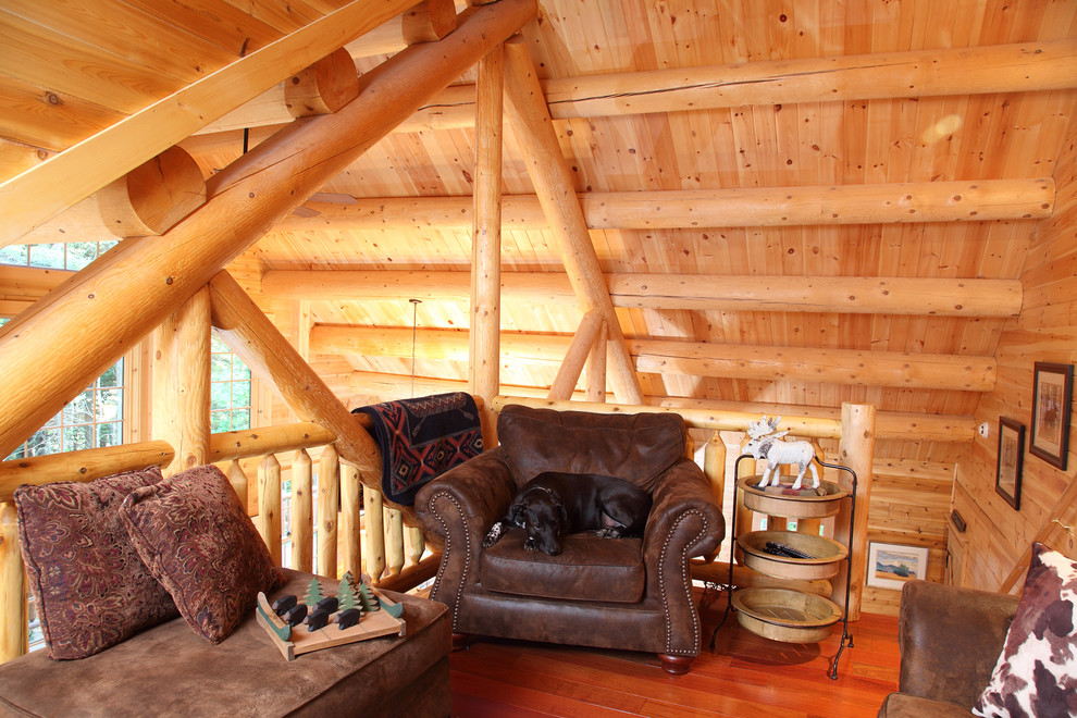 Exempel på ett litet rustikt allrum på loftet, med mellanmörkt trägolv