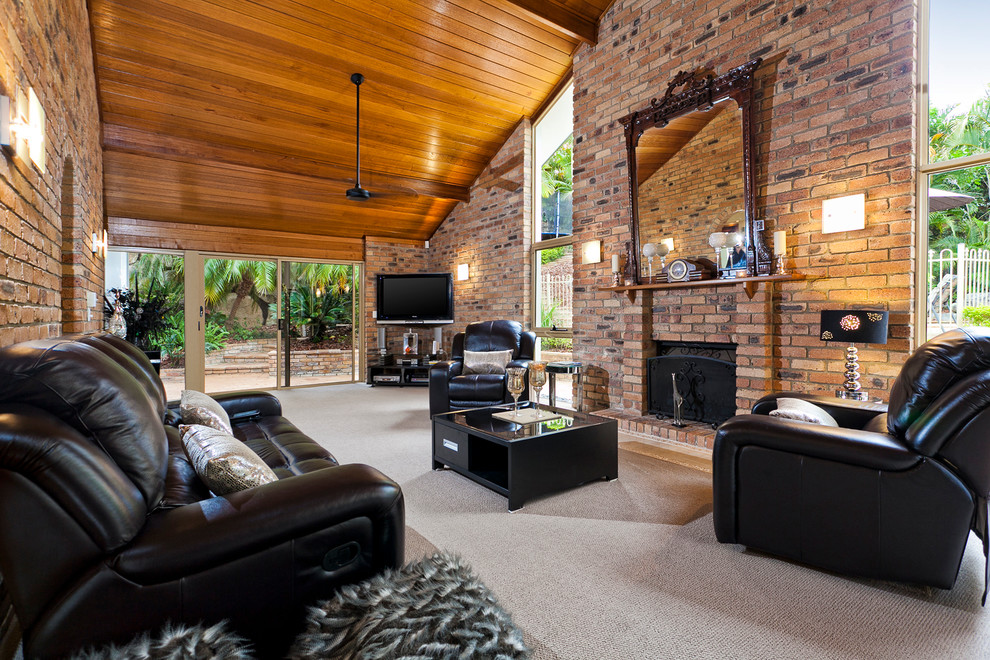 Idée de décoration pour une très grande salle de séjour vintage ouverte avec un mur marron, moquette, une cheminée standard, un manteau de cheminée en brique et un téléviseur d'angle.
