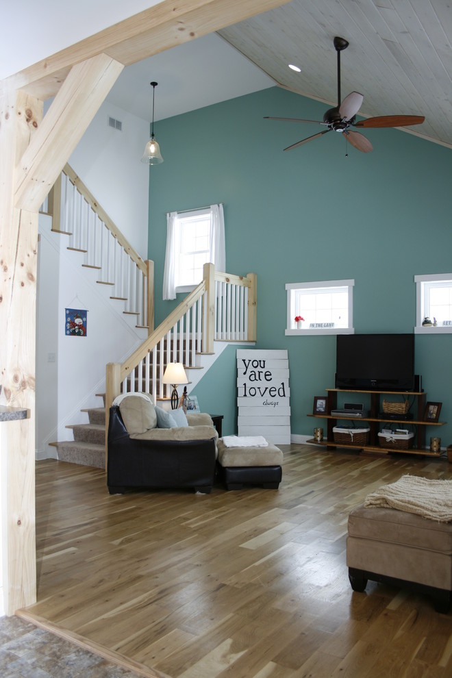 Mittelgroßes, Offenes Maritimes Wohnzimmer mit blauer Wandfarbe, braunem Holzboden, freistehendem TV, Eckkamin und Kaminumrandung aus Metall in Richmond