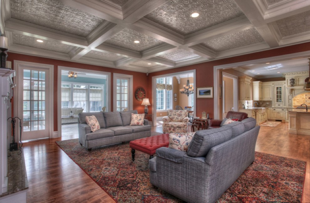 Ejemplo de sala de estar abierta tradicional grande con paredes rojas, suelo de madera en tonos medios, pared multimedia y suelo marrón