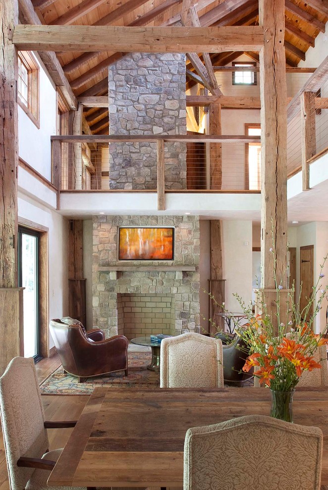 Großes, Offenes Rustikales Wohnzimmer mit beiger Wandfarbe, braunem Holzboden, Kamin und Kaminumrandung aus Stein in Philadelphia
